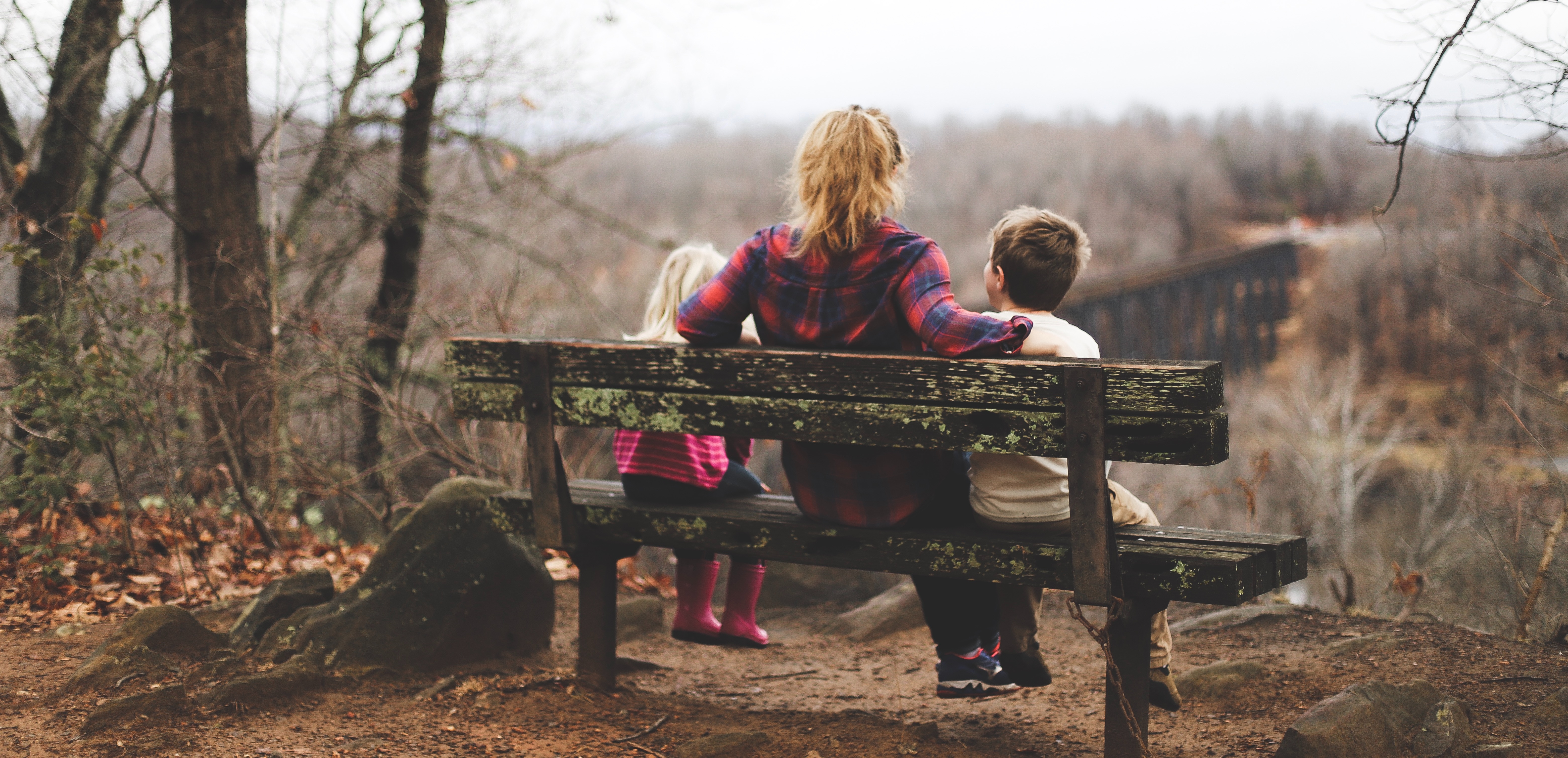 Mother sitting on a bench with her children outdoors